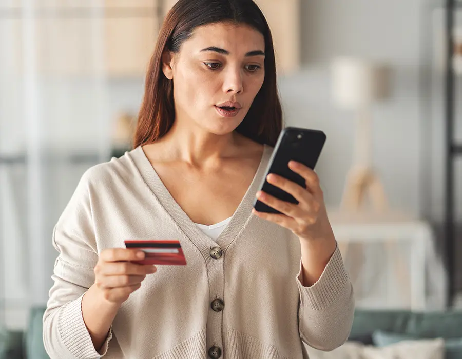 woman holding phone looking startled